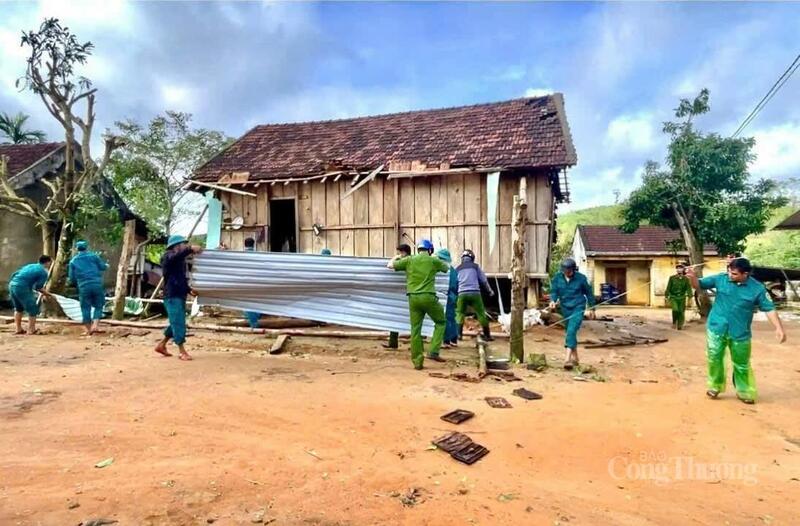 Các cán bộ chiến sĩ công an sửa chữa, lợp lại những mái nhà bị hư hỏng nặng.