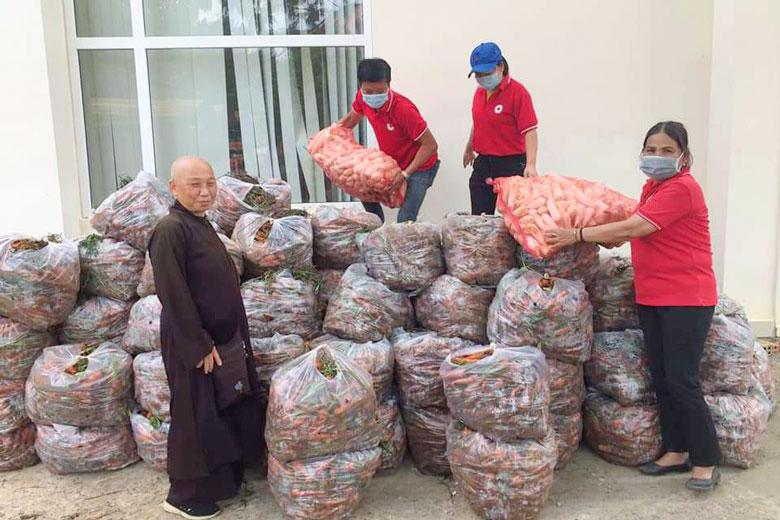 Các thành viên đội tình nguyện đang bốc hàng để chuyển lên xe gửi về các địa phương đang bị ảnh hưởng bởi dịch COVID-19