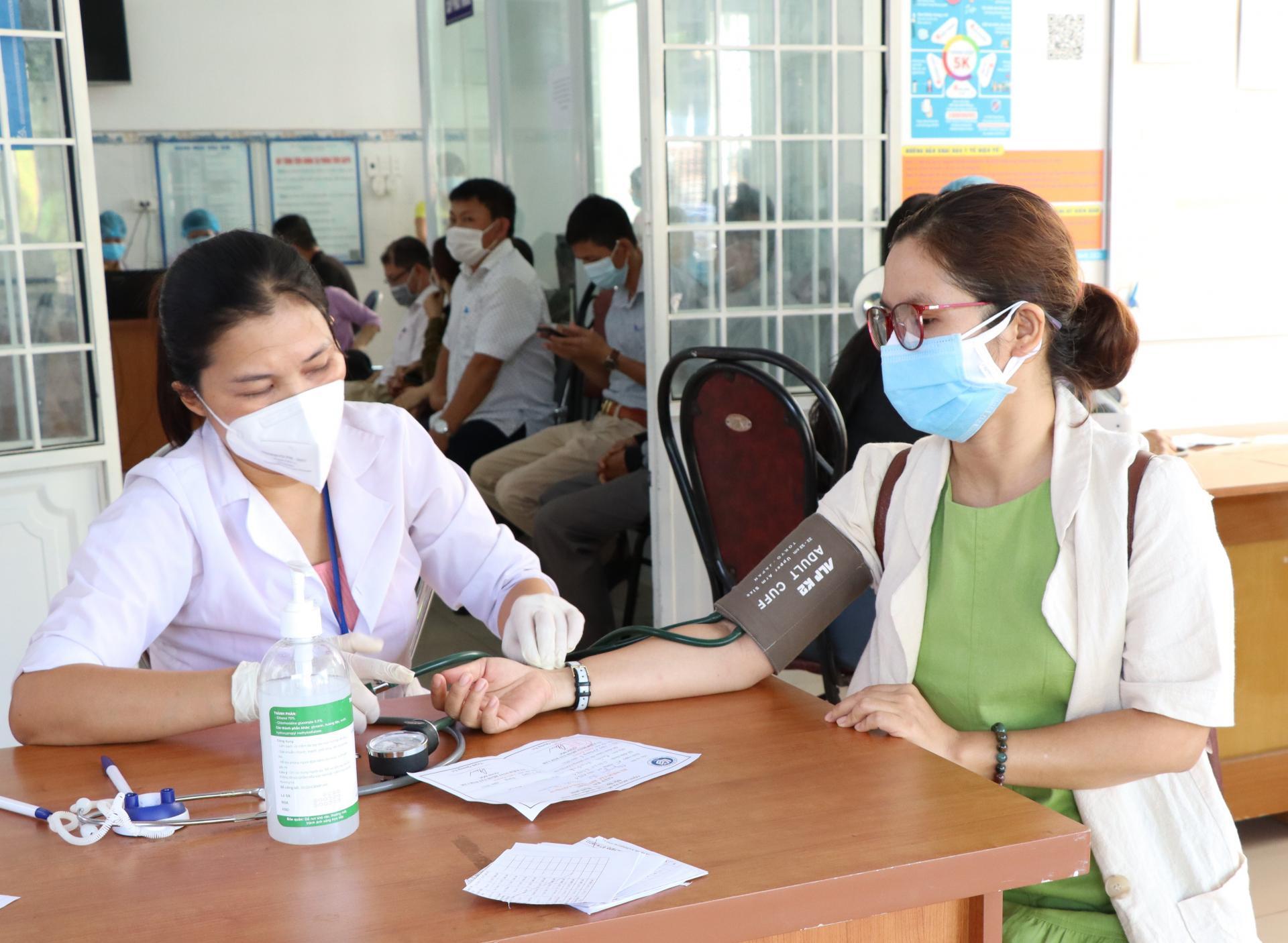 Lực lượng y tế khám sàng lọc trước tiêm vắc xin phòng COVID-19 cho người dân.