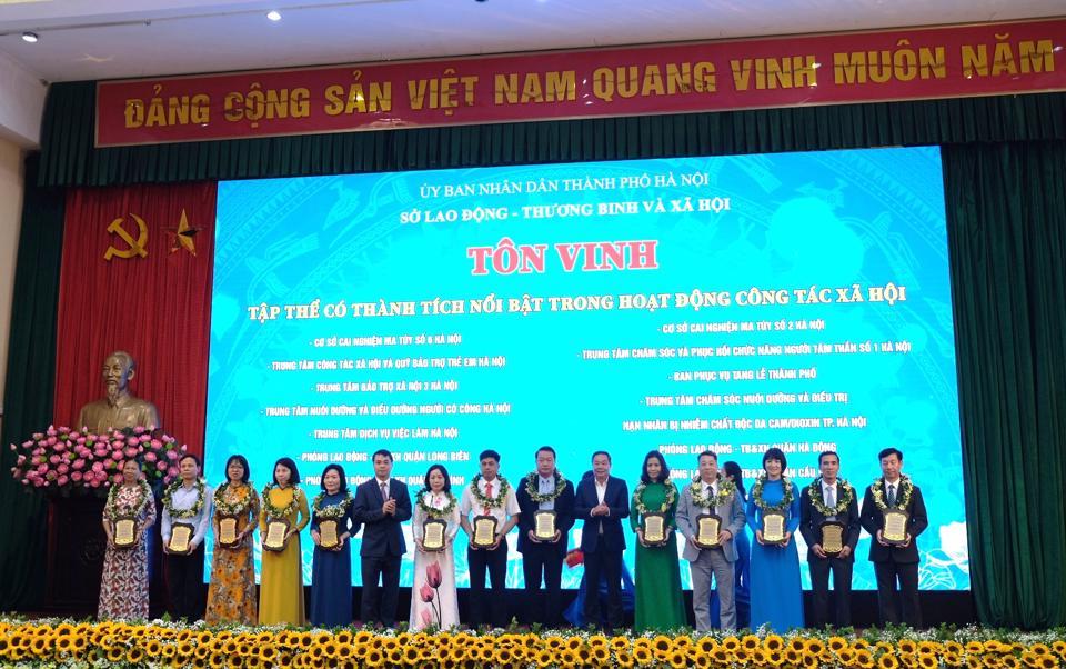 Phó Chủ tịch Thường trực UBND Thành phố Hà Nội Lê Hồng Sơn tặng bảng vàng tôn vinh các tập thể và cá nhân thực hiện nhiệm vụ công tác xã hội. Ảnh: Trần Oanh.