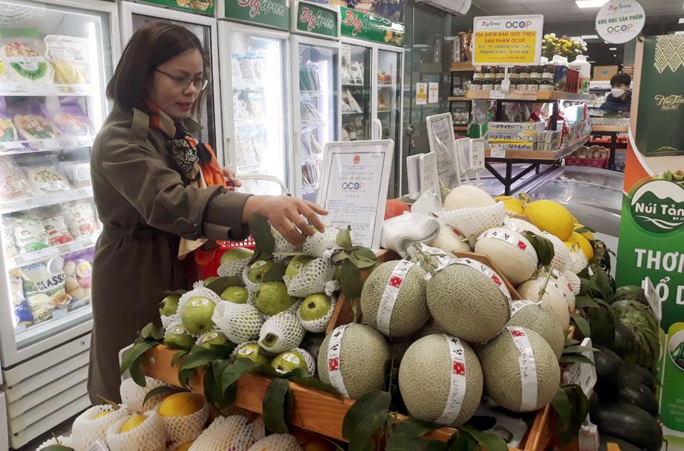 Người tiêu dùng mua nông sản đạt tiêu chuẩn OCOP tại điểm bán và giới thiệu sản phẩm OCOP quận Hoàng Mai. Ảnh: Hoài Nam