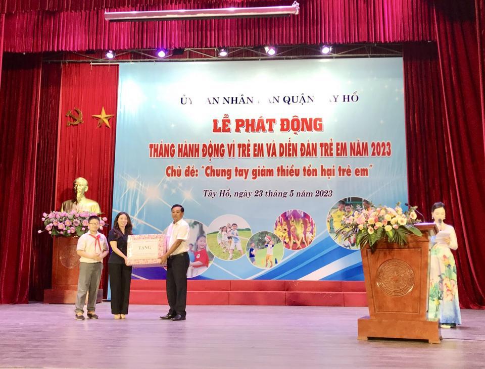 Phó Giám đốc Sở LĐTB&XH Hà Nội Đinh Hồng Phong trao quà cho trẻ em quận Tây Hồ. (Trong ảnh: Phó Chủ tịch UBND quận Tây Hồ Bùi Thị Lan Phương, trẻ em nhận quà).