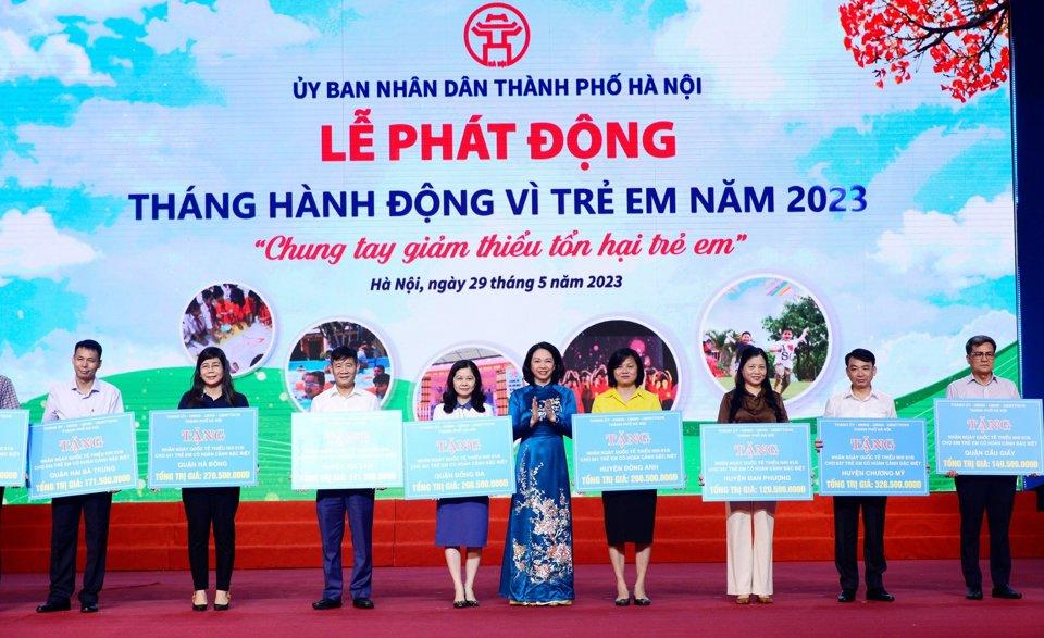 Phó Chủ tịch UBND TP Hà Nội Vũ Thu Hà trao biển tượng trưng kinh phí hỗ trợ trẻ em cho lãnh đạo các quận, huyện. Ảnh: Phạm Hùng. 