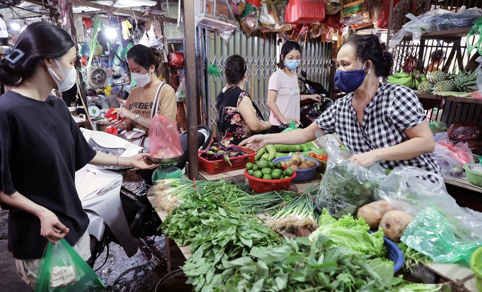 Người tiêu dùng mua rau xanh tại chợ Kim Liên. Ảnh: Hoài Nam