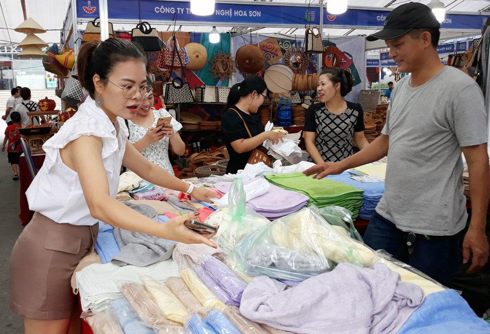 Người tiêu dùng tiếp cận sản phẩm dệt may của các làng nghề Hà Nội tại Chương trình Mạng lưới liên kết hợp tác sản xuất và tiêu dùng bền vững trong chuỗi ngành dệt may – thời trang năm 2023. Ảnh: Hoài Nam