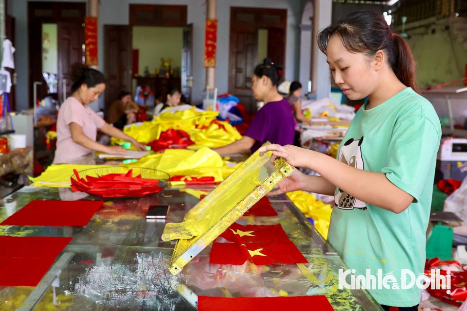 Những ngày gần với lễ kỉ niệm Quốc khánh 2/9 và khai giảng năm học mới, các xưởng may trong làng lúc nào cũng ngập sắc đỏ, máy móc chạy hết công suất để đáp ứng các đơn hàng.