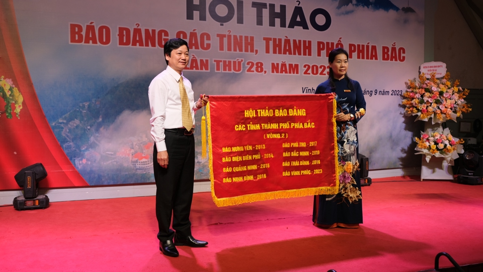 Tổng Biên tập báo Vĩnh Phúc Hoàng Thị Nhung trao cờ luân lưu cho Tổng Biên tập báo Bắc Giang Trần Văn Ánh - đơn vị sẽ đăng cai tổ chức Hội thảo báo Đảng các tỉnh, thành phố phía Bắc lần thứ 29. 