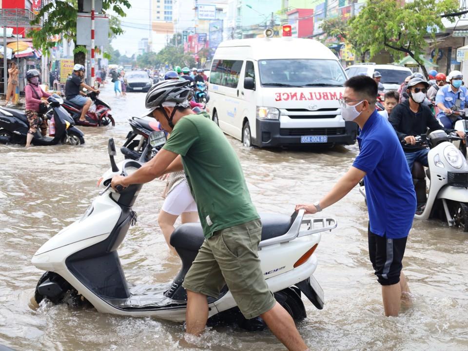 Người dân chật vật di chuyển qua khu vực ngập sâu.