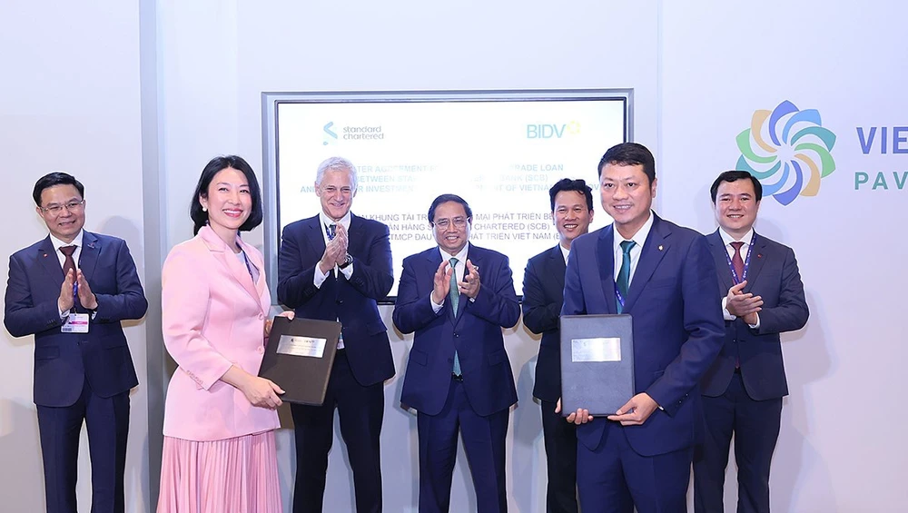 Ông Lê Ngọc Lâm - Tổng giám đốc BIDV và bà Michele Wee – Tổng Giám đốc Standard Chartered Bank Việt Nam trao Thỏa thuận khung Tài trợ thương mại Phát triển bền vững. 