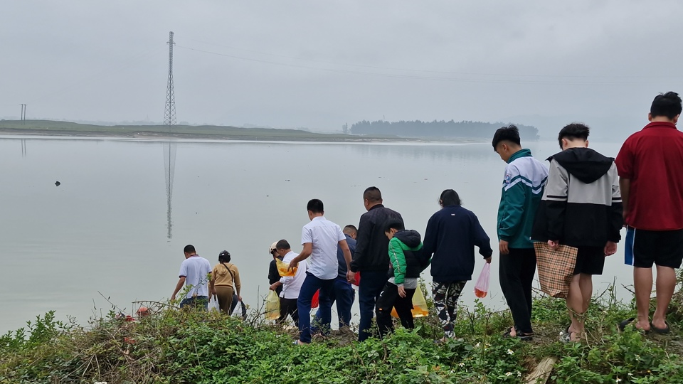 Dọc bờ sông Lam, người dân chen chúc, xếp thành từng hàng dài thả cá phóng sinh xuống sông Lam.