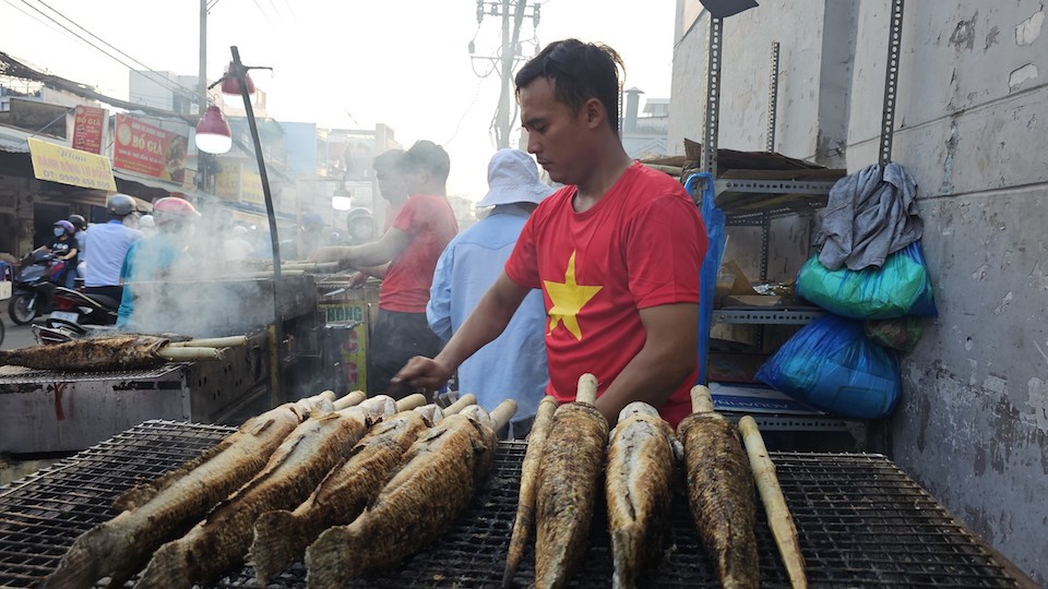 Màu khói xám quyện cùng hương thơm món cá lóc nướng khiến một đoạn ngắn đường Tân Kỳ Tân Quý trở thành phố cá lóc nướng giữa Sài Gòn. Ảnh: Quang Minh