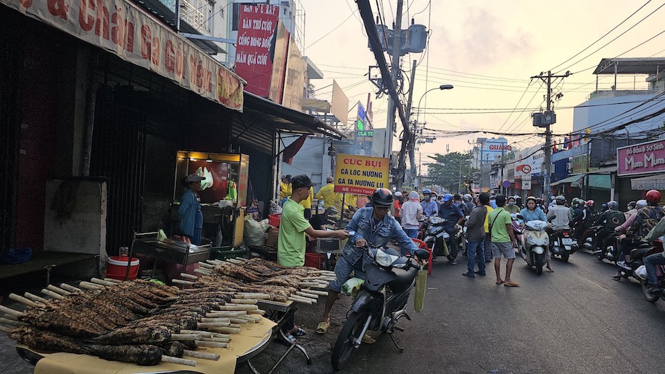 Từ sáng sớm ngày 19/2, phố cá lóc nướng lớn nhất tại TP Hồ Chí Minh đã nhộn nhịp, xe cộ liên tục tấp vào hỏi mua cá, mùi cá lóc nướng tỏa ra thơm nghi ngút khắp con đường. Ảnh: Quang Minh