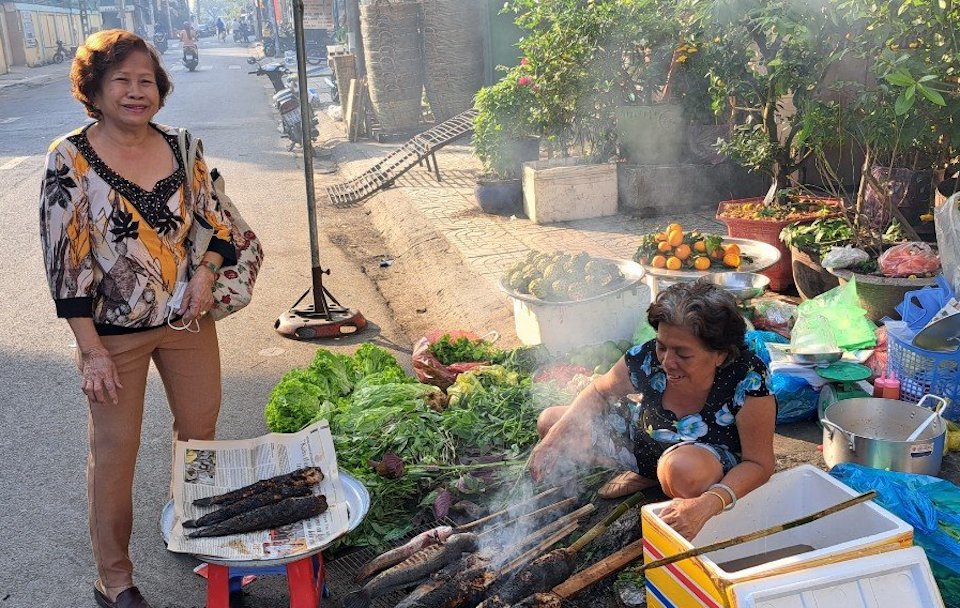 Bà Ánh Tuyết đang nướng cá lóc cho khách. Ảnh: Tân Tiến