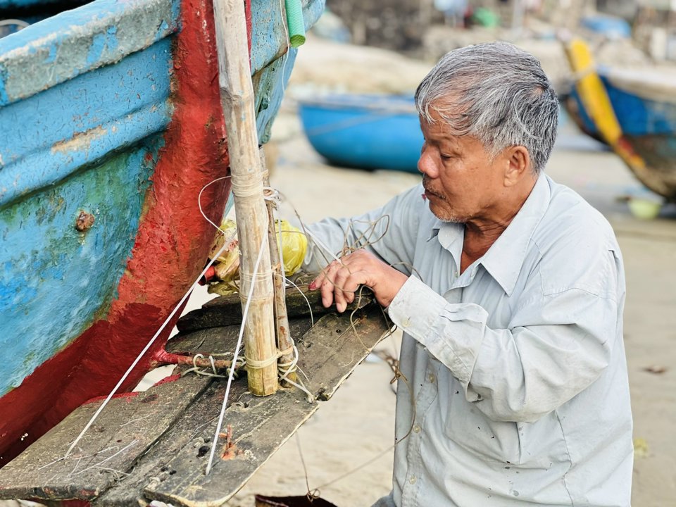 Lão ngư Nguyễn Văn Bảy tu sửa lại chiếc thúng máy.