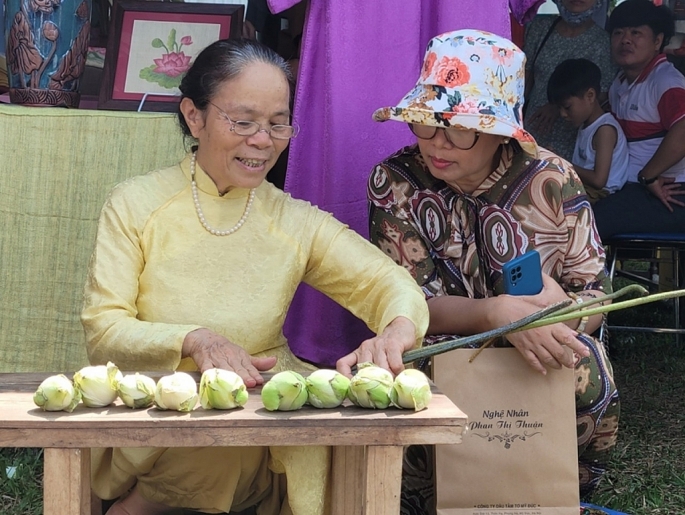 Nghệ nhân Phan Thị Thuận trình diễn thao tác rút tơ sen tại Festival Nghề truyền thống Huế năm 2023. Ảnh: Thanh Hương  