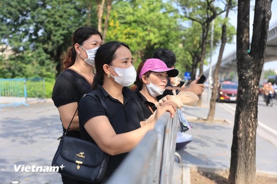 Càng về trưa trời càng nắng nóng, nhưng đoàn người vẫn trật tự, trang nghiêm xếp hàng trong khu vực rào chắn. Ảnh: TTXVN