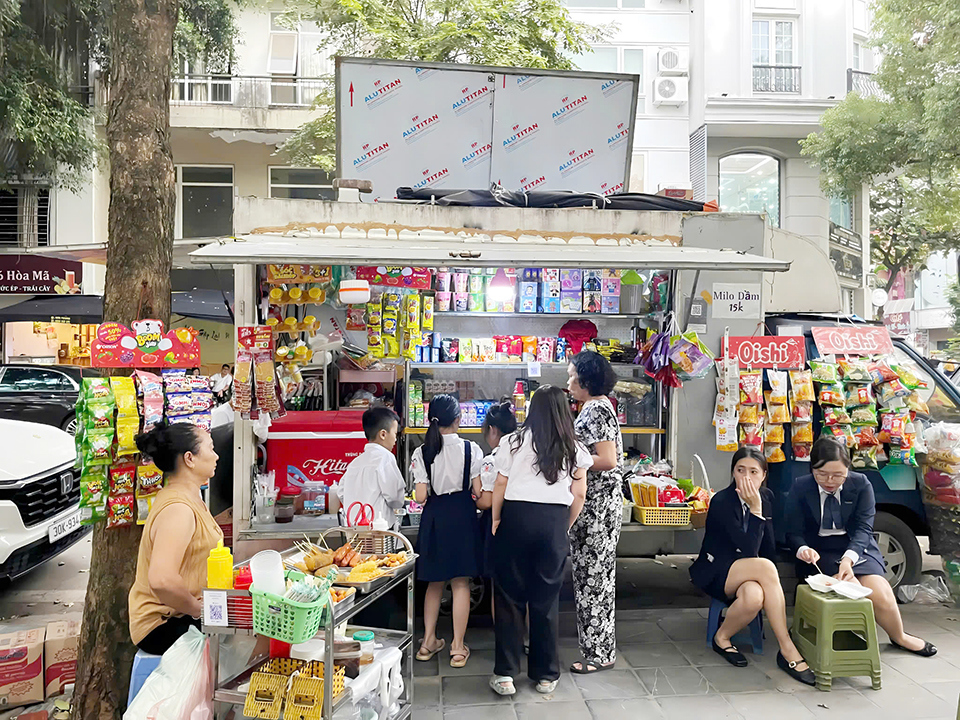 Hàng xe lưu động tại một cổng trường tiểu học trên địa bàn Hà Nội sau giờ tan trường. 