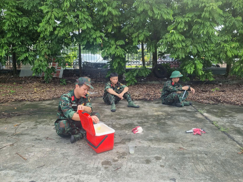 Cán bộ, chiến sĩ tranh thủ nghỉ ngơi ngắn giữa ca làm việc trong điều kiện nắng nóng ngoài trời. Ảnh: Hải Sơn