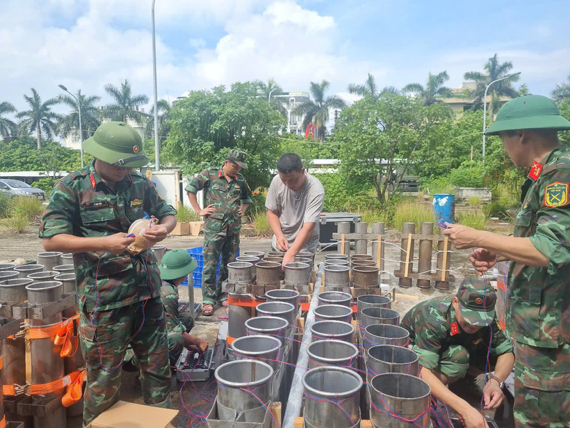 Các cán bộ, chiến sĩ kỹ thuật đang tiến hành nạp những quả pháo hoa cuối cùng vào nòng, hoàn tất công đoạn chuẩn bị trước giờ bắn. Ảnh: Hải Sơn