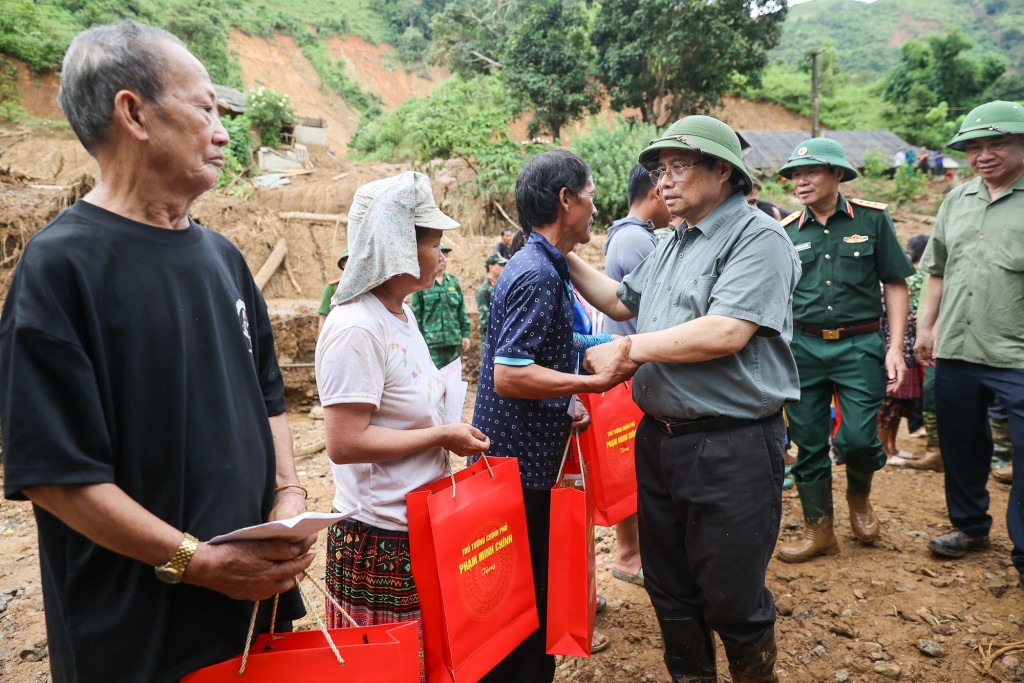 Thủ tướng tặng quà cho người dân - Ảnh: VGP/Nhật Bắc