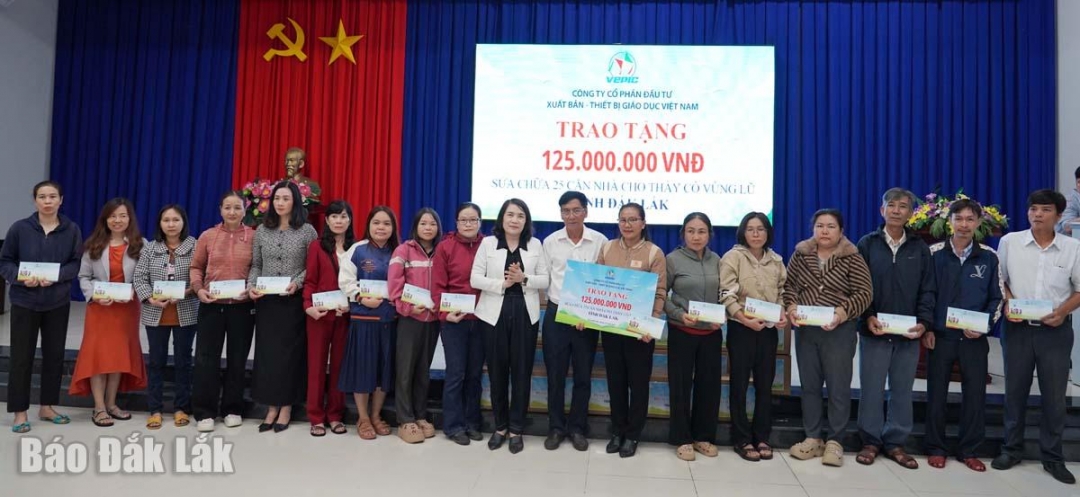 Đại diện công ty trao tiền hỗ trợ cho các giáo viên có nhà bị thiệt hại do mưa lũ vừa qua.