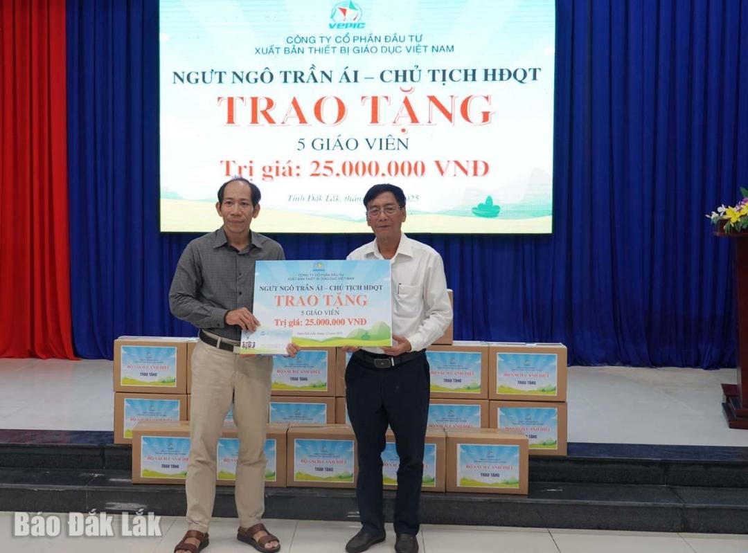 Đại diện công ty trao tiền hỗ trợ của Nhà giáo ưu tú Trần Ngọc Ái cho giáo viên có nhà bị thiệt hại do mưa lũ.