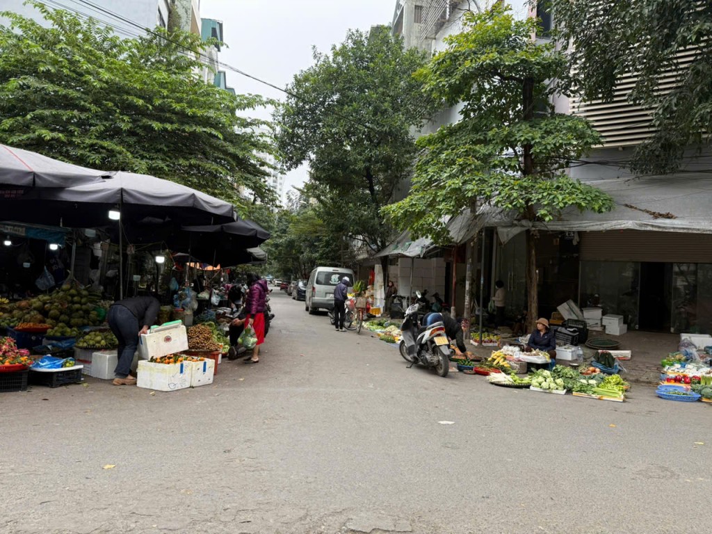 Chợ dân sinh họp tràn ra lòng đường – Xe máy, người mua bán đan xen trong không gian chật hẹp. Chợ dân sinh họp tràn ra lòng đường – Xe máy, người mua bán đan xen trong không gian chật hẹp.