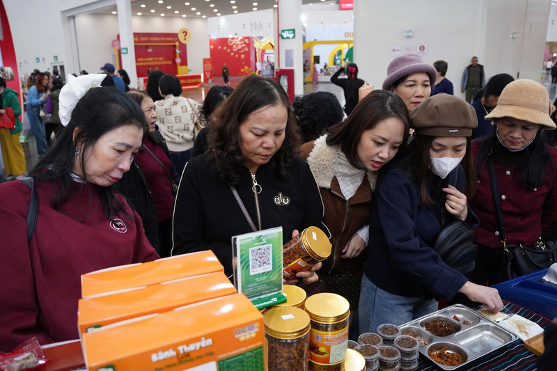 Người dân và du khách tìm hiểu, lựa chọn sản phẩm phục vụ nhu cầu mua sắm, biếu tặng dịp Tết tại Hội chợ Mùa Xuân 2026, nơi quy tụ hàng hóa phong phú từ nhiều vùng miền. (Ảnh: Mai Linh)