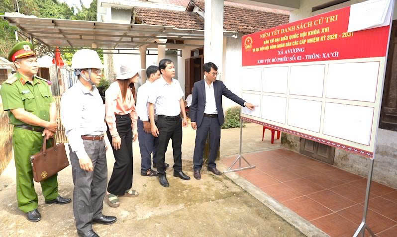 Lãnh đạo xã A Vương kiểm tra việc lập, niêm yết danh sách cử tri, cơ sở vật chất, phương án đảm bảo an ninh, trật tự.... Ảnh: Bình An
