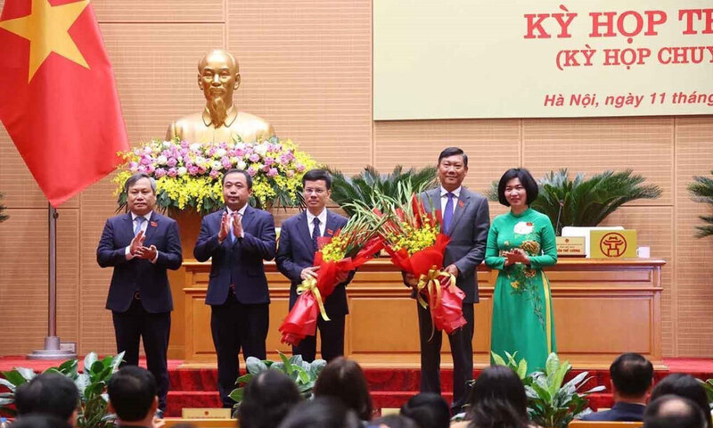 Ông Đỗ Anh Tuấn (thứ hai từ phải qua) và ông Bùi Duy Cường (thứ ba từ phải qua) nhận hoa chúc mừng từ lãnh đạo TP. Hà Nội. Ảnh: UBND TP. Hà Nội