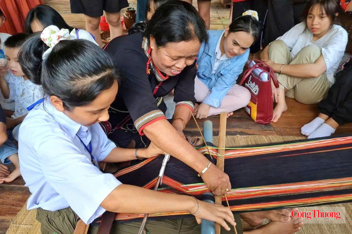 Bà H’Yam chỉ dạy dệt thổ cẩm cho học sinh đến tham quan tại buôn Tơng Jú.