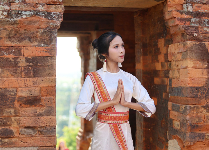Thiếu nữ Chăm cầu nguyện những điều tốt đẹp đến với gia đình và bản thân tại tháp Pô Klong Garai. Ảnh: Mai Đông - Thanh Sơn.