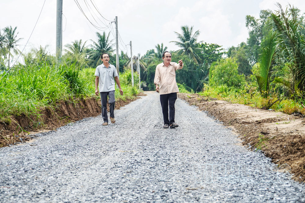 Ông Phạm Văn Thích - Trưởng ấp Giồng Gạch và ông Lê Văn Em, Tổ số 3, ấp Giồng Gạch (bìa trái) giới thiệu tuyến đường bằng sự chung tay góp sức của người dân.